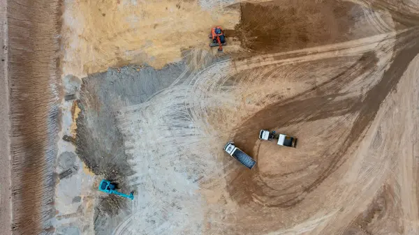 Kazı kazıları toprağı inşaat sahasında taşır, Kazı ve inşaat sahasında kazı yapar, Crawler kazıcı kazıcıları inşaat alanındaki taşımacılık kamyonunda toprak çakılları, Top view