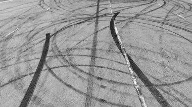 Asfalt yol yarış pistinde en tepedeki araba lastiği izleri asfalt yol yarış pisti dokusu ve arka planında soyut araba lastiği izleri yarış pisti dokusunda siyah araba tekerlek izleri ve arka planda siyah araba lastiği izleri..