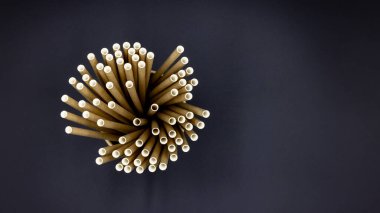 Siyah arka planda kağıt pipetler, kağıt pipetler, açık havada içmek için aksesuarlar, ekoloji çevre dostu geri dönüşüm, çevre dostu yeniden kullanılabilir kağıt pipetler, kahve veya çay içmek için Kraft kağıdı pipetleri.