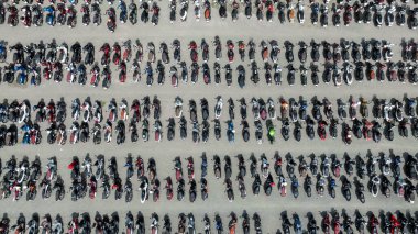 Caddeye park etmiş motosikletlerin, motosikletlerin otoparkına park edilmiş motosikletlerin, beton zemindeki motosikletlerin hava manzarası..