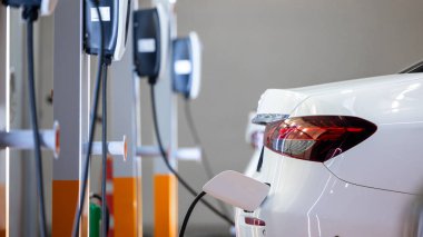 EV şarj istasyonu ve elektrikli araba şarj istasyonu EV pili şarj istasyonu, elektrikli motoru olan araç prizi, EV şarjı temiz enerji, araba parkındaki şarj noktası.
