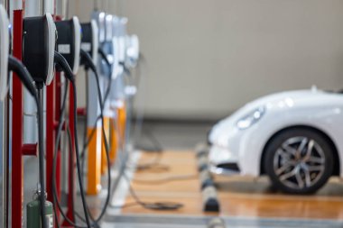 EV şarj istasyonu ve elektrikli araba şarj istasyonu EV pili şarj istasyonu, elektrikli motoru olan araç prizi, EV şarjı temiz enerji, araba parkındaki şarj noktası.