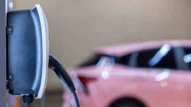 EV şarj istasyonu ve elektrikli araba şarj istasyonu EV pili şarj istasyonu, elektrikli motoru olan araç prizi, EV şarjı temiz enerji, araba parkındaki şarj noktası.