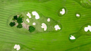 Yeşiller, yeşil çimenler ve kum sığınağı, golf sahası yeşil çimenler ve ağaçlar ve yeşil golf sahası olan hava manzaralı golf sahası..