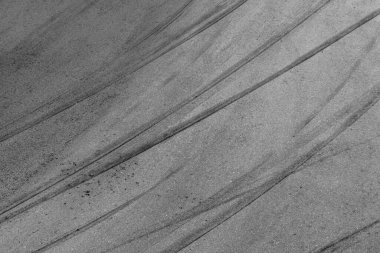 Yarış pistinde siyah lastik izleri olan soyut asfalt sokak arka planı, desen ve arka plan araba otomobili ve patinaj izleri..