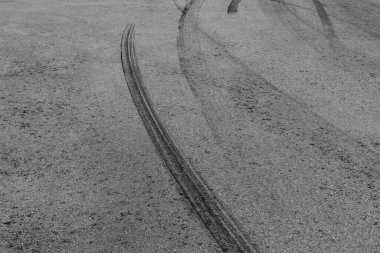 Yarış pistinde siyah lastik izleri olan soyut asfalt sokak arka planı, desen ve arka plan araba otomobili ve patinaj izleri..