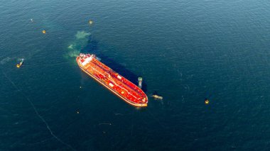 Petrol terminalindeki rafineriye yükleme ve boşaltma yapan hava manzaralı petrol gemisi, lojistik taşımacılık, deniz nakliye tankeri, limanda kırmızı ham petrol tankeri gemisi..