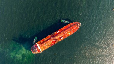 Petrol terminalindeki rafineriye yükleme ve boşaltma yapan hava manzaralı petrol gemisi, lojistik taşımacılık, deniz nakliye tankeri, limanda kırmızı ham petrol tankeri gemisi..