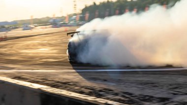 Araba sürükleniyor, bulanık görüntü dağılımı yarış arabası hız yolunda yanan lastiklerden çıkan dumanlar, hız yolunda sürüklenen araba, profesyonel sürücü sürücüsü sürüş yapan araba..