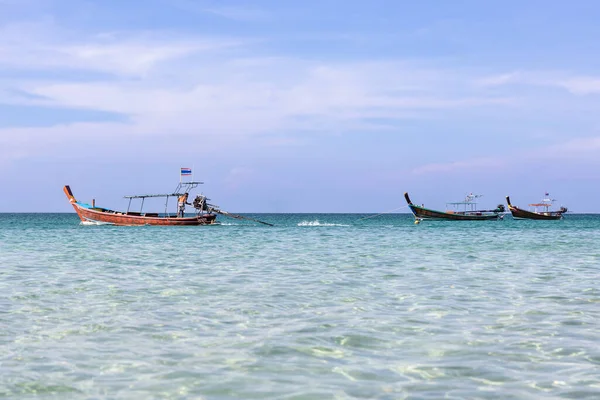Tayland, Phuket 'teki Kata Sahili' nin şeffaf denizinde uzun bir Tayland teknesi..