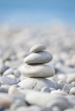 Deniz kıyısındaki gri deniz taşları piramidi