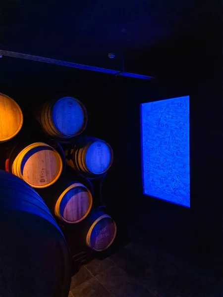 照明付きの古いセラーギリシャのワイナリーで積層オーク樽とボトル — ストック写真