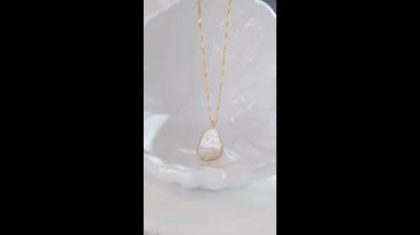 Beyaz arkaplanda altın zincirli inci kolye