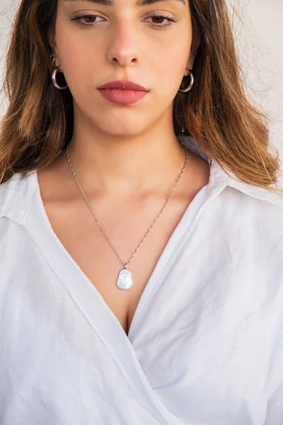 A beautiful young woman wearing a silver chain pearl necklace and silver earrings. Beautiful valentine\'s gifts.