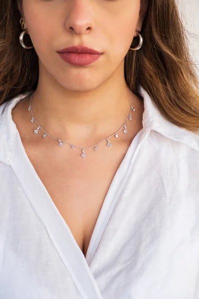 A beautiful young woman wearing a silver clear necklace and silver earrings. Beautiful valentine\'s gifts.