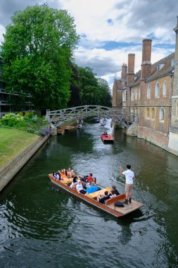 Cambridge, İngiltere - 21 Haziran 2023: Turistler Queen 's College' a ait Matematik Köprüsü 'nün altında ve yakınında Cam Nehri' nde kürek çekiyorlar