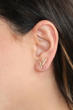 Woman wearing beautiful stud earrings with zirconia. Beautiful valentine's gift. clipart