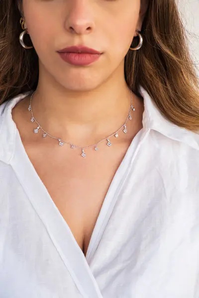 A beautiful young woman wearing a silver clear necklace and silver earrings. Beautiful valentine's gifts.