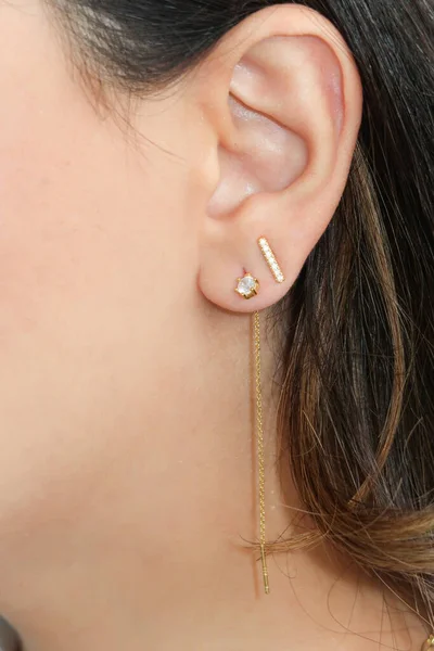 Woman wearing beautiful dangky and stud earrings with zirconia. Beautiful valentine\'s gift.