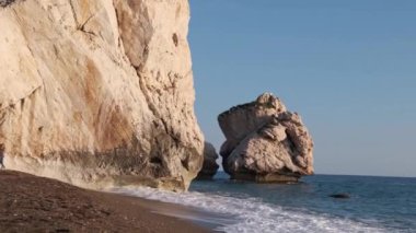 İnsanlar Petra tou Romiou 'da, Kıbrıs' ın Paphos kentinde, Afrodit 'in Yunan mitolojisinde doğduğu yerde plajın keyfini çıkarıyorlar..