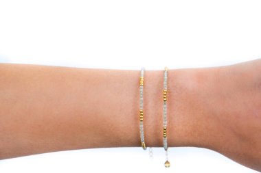 Güzel kadın bilekliği takıyor, beyaz arka plana takılmış taştan bilezikler takıyor. Güzel sevgililer günü hediyeleri.