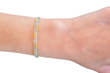 Güzel kadın bilekliği takıyor, beyaz arka plana takılmış taştan bilezikler takıyor. Güzel sevgililer günü hediyeleri.