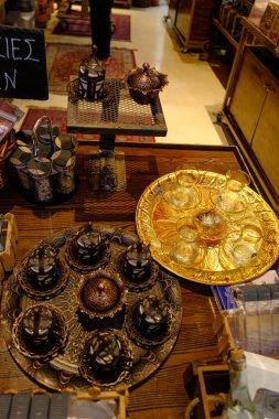 Selanik 'teki bir dükkanda sergilenen küçük fincanlar ve dekoratif tepsiler de dahil olmak üzere bir dizi süslü pirinç, bakır kahve ve çay seti..