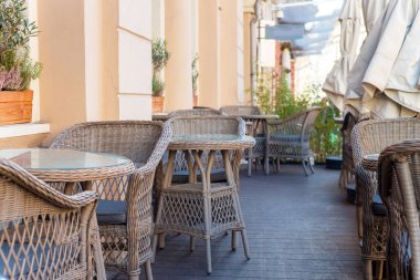 Restaurant interior tables near a restaurant. Close up shot of empty cafeteria or restaurant tables with chairs on street.