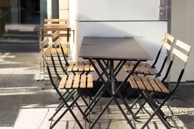 Restaurant interior tables near a restaurant. Close up shot of empty cafeteria or restaurant tables with chairs on street.