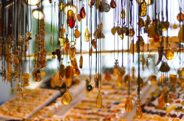 Kolyeler ve diğer kehribar eşyalar. Farklı boylarda ve renklerde kehribar. Turistler için kehribar taşı sergisi.