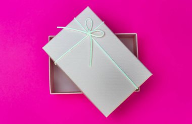 Pembe arka planda küçük pembe hediye kutusu.