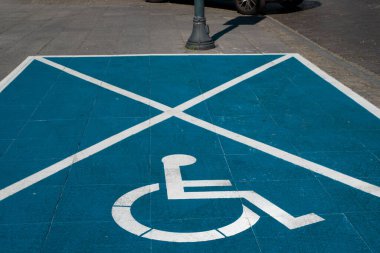 Asfalt araba parkı süpermarkette ya da alışveriş merkezinde özürlü sürücüye ayrılmıştır. Engelliler için araba park yeri. Asfalt park alanında tekerlekli sandalye boyası. Engelli park yeri.