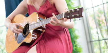 Akustik gitar çalan güzel bir Asyalı kadın. moda yaşam tarzı