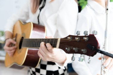 Akustik gitar çalan güzel bir Asyalı kadın. moda yaşam tarzı