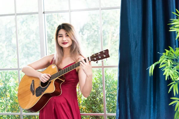 アコースティックギターを弾く美しい若いアジアの女性 ファッションライフスタイル — ストック写真
