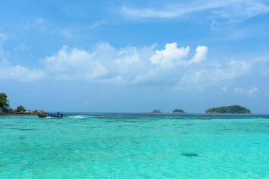 Güzel Andaman denizi, Tropikal Turkuaz berrak mavi deniz ve mavi gökyüzü arka planına sahip Pattaya plajında beyaz kum plajı - yaz tatili yolculuğu. Tarutao Ulusal Parkı ve Koh Lipe Satun, Tayland
