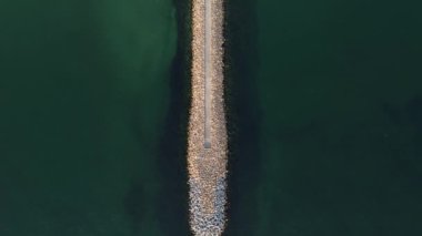 Aerial footage of a seaside stone pier at the Black Sea shore, Romania