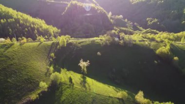 Karpat dağlarının vadilerinde uzak Romen köyü olan havadan dağ manzarası. İlkbaharda ağaçların açtığı kırsal bir manzara.