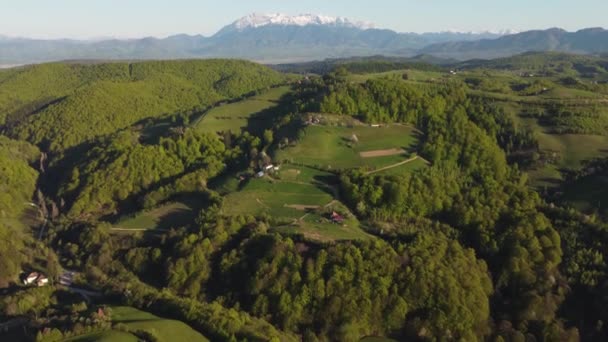空中山地景观与遥远的罗马尼亚村庄在喀尔巴阡山脉的山谷上山丘 春天的乡村景色 树木盛开 — 图库视频影像