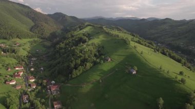 Transilvanya 'daki Karpatların eteğindeki yeşil tepelerin havadan görünüşü. Bran köyünün yaz manzarası