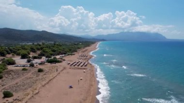 Yunanistan 'ın Ayiou Nikolaou kentinde ikonik turkuaz ve safir plajın hava aracı videosu. Paralia Ayiou Nikolaou. Güzel bir kumsal manzarası.