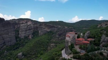 Dik kayalıkların tepesindeki antik manastırların havadan görünüşü. Metheora, Yunanistan. İnsanoğlunun muhteşem çalışmasının insansız hava aracı çekimi. Meteora tapınakları