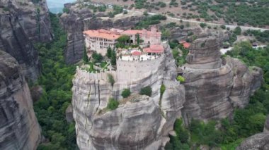 Dik kayalıkların tepesindeki antik manastırların havadan görünüşü. Metheora, Yunanistan. İnsanoğlunun muhteşem çalışmasının insansız hava aracı çekimi. Meteora tapınakları