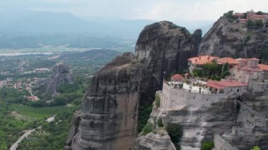 Dik kayalıkların tepesindeki antik manastırların havadan görünüşü. Metheora, Yunanistan. İnsanoğlunun muhteşem çalışmasının insansız hava aracı çekimi. Meteora tapınakları