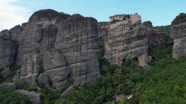 Dik kayalıkların tepesindeki antik manastırların havadan görünüşü. Metheora, Yunanistan. İnsanoğlunun muhteşem çalışmasının insansız hava aracı çekimi. Meteora tapınakları