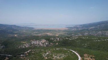Yunanistan 'daki Karla Gölü' nün dağlarla çevrili havadan görünüşü. İHA 'lar yoldan geçerken ateş etti.