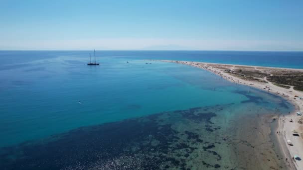 象徴的なターコイズとサファイア湾の空中ドローンビデオとPossidi岬 Halkidiki ギリシャのビーチ ボートと砂浜の美しい景色 — ストック動画