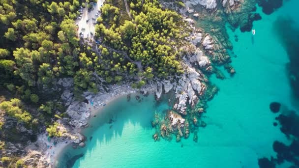 アトス山の景色を望むギリシャのシトニアの象徴的なターコイズとサファイアパラダイスビーチの空中ドローンビデオ 高い岩に囲まれた砂浜の美しい景色 — ストック動画