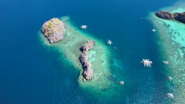 Siete Pecados Siete 'nin mavi denizle çevrili 4K hava aracı videosu. Coron, Palawan. Filipinler.