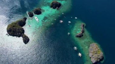 Siete Pecados Siete 'nin mavi denizle çevrili 4K hava aracı videosu. Coron, Palawan. Filipinler.
